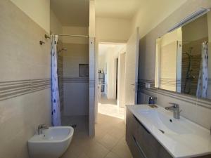 ein Bad mit einem Waschbecken, einem WC und einer Dusche in der Unterkunft Appartamenti Mirella in Capoliveri