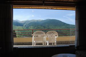 dos sillas blancas sentadas junto a una ventana con montañas en Apartamentos SNÖ Edelweiss, en Cerler