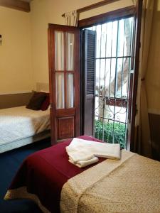 1 dormitorio con cama y ventana con vistas en Hotel Rivera, en Colonia del Sacramento