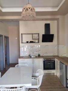 a kitchen with a white table and chairs and a sink at Cavo D' Oro Complex in Kavos