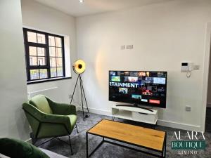 a living room with a tv and a chair and a table at 3 Floor Townhouse Luxury Living Alara Boutique in Birmingham