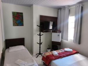 a room with two beds in a room with a window at Pousada Souza Castro in Ouro Preto