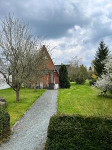 a gravel path leading to a red brick house at Gemütliches Ferienhaus mit sonniger Terrasse Frankenwald nähe Badesee Smart-TV in Lichtenberg