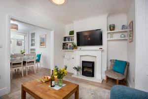 a living room with a fireplace and a tv on a wall at Holmdale House in Sidmouth