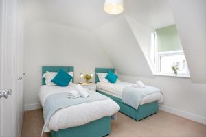 two twin beds in a attic room with a window at Holmdale House in Sidmouth