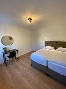Schlafzimmer mit einem Bett, einem Schreibtisch und einem Spiegel in der Unterkunft Nisay Home - 4 Room Apartment - Nr2 in Ludwigsburg