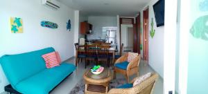sala de estar con sofá azul y sillas en Apartamento Frente al Mar, en Santa Marta
