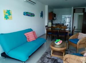 a living room with a blue couch and a table at Apartamento Frente al Mar in Santa Marta