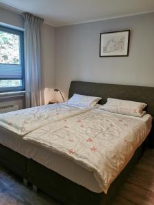 1 dormitorio con 1 cama grande con manta en Ferienwohnung in Waldrandlage in Nationalpark Schleiden / Eifel, en Schleiden