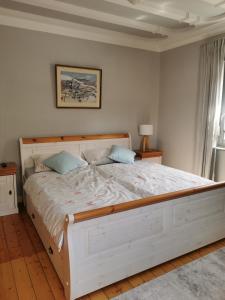 - une chambre avec un grand lit blanc et des oreillers bleus dans l'établissement Ferienwohnung in Waldrandlage in Nationalpark Schleiden / Eifel, à Schleiden