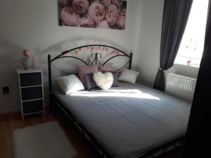 a bedroom with a bed with pillows and a window at Nati Nagy Apartman in Siófok