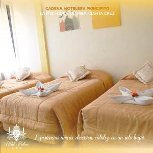 Dos camas en una habitación con flores. en Hotel Palace Capitol en Cochabamba