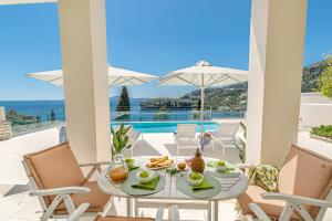 a patio with a table and chairs with a view of the ocean at Kalami Beach - Villa Anastasia in Kalami