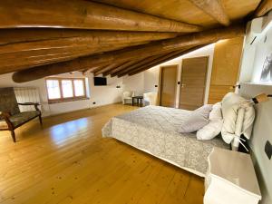 una camera con letto in una stanza con soffitti in legno di B&B Tenuta Le Rondini a Gavardo