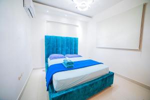 a bedroom with a blue bed in a white room at SFMverdana Rental in San Francisco de Macorís