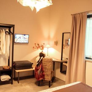 una camera da letto con scrivania, sedia e specchio di B&B Belelì Daramba a Cuneo