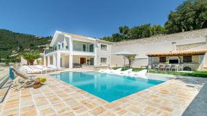 a villa with a swimming pool and a house at Kalami Beach - Villa Mara in Kalami
