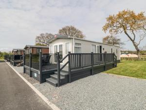 a mobile home with a porch and a fence at Lodge 7 - Seabreeze Retreat in Bridlington