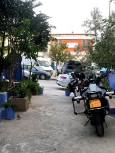 una motocicleta estacionada en un estacionamiento con coches en Dar Saida Hora, en Chefchaouen