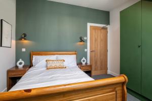 um quarto com uma cama e uma parede verde em Remodelled Luxury 3 Bed Apartment em Aberdeen