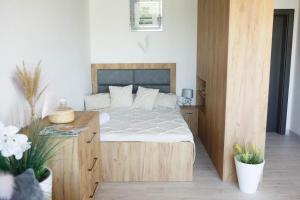 sypialnia z dużym łóżkiem i drewnianą szafką w obiekcie Apartamenty Scarlet w mieście Darłowo +24 zdjęcia
