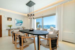 a dining room with a table and chairs and a large window at Kalami Beach - Villa Mara in Kalami