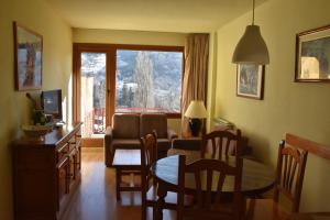 sala de estar con mesa y sala de estar con vistas. en Apartamentos SNÖ Edelweiss en Cerler