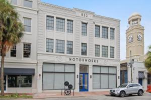 a white building with a clock tower on a street at Roami at Motorworks in New Orleans