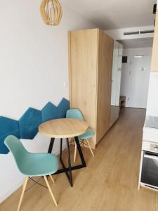 une petite cuisine avec une table et des chaises bleues dans l'établissement Czar wakacji, à Sarbinowo
