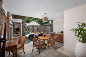 a kitchen and dining room with a table and chairs at Visesa Ubud Resort in Ubud