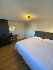 ein Schlafzimmer mit einem großen weißen Bett und einem Tisch in der Unterkunft Nisay Home - 3 Room Apartment - Nr3 in Ludwigsburg
