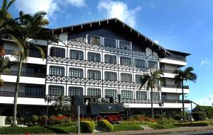 a large building with palm trees in front of it at Loft com vista para Vila Germânica 309 in Blumenau
