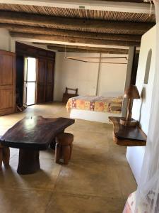 a bedroom with a bed and a wooden table in a room at Cabañas Las 3 Marias in San Agustinillo