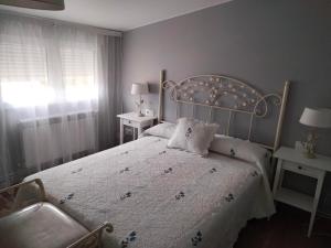 ein Schlafzimmer mit einem Bett, zwei Tischen und einem Fenster in der Unterkunft A de Sabardes in Sabardes