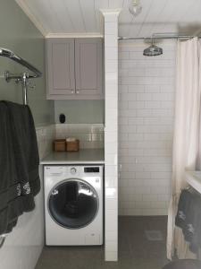 een keuken met een wasmachine in de badkamer bij North Wing - Sviten in Enköping