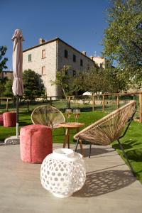 a patio with two chairs and a table and an umbrella at Agriturismo La Via Dell'Oliviera in Ciciano