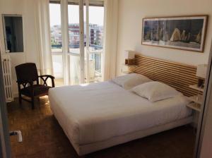 um quarto com uma grande cama branca e uma varanda em 2 pièces 500 m de la mer em Antibes