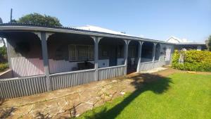 a house with a fence and a yard at Four Seasons Self-Catering Guest House in Graskop