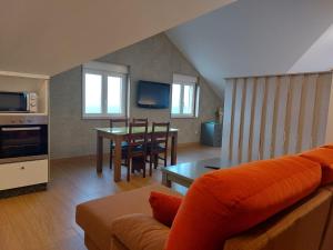 a living room with a couch and a table at Mirador do faro Touriñan in Muxia