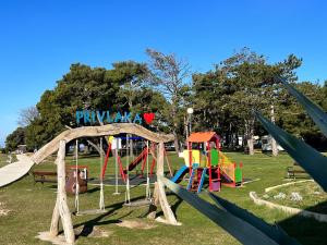 a park with a playground with a slide at CARAONE DALMACIA LAKÓKOCSIK- A TENGERPARTON in Privlaka