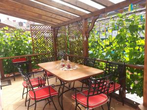 een houten tafel en stoelen op een balkon met planten bij Nati Nagy Apartman in Siófok