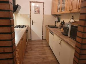 cocina con armarios de madera y suelo de madera en Nati Nagy Apartman, en Siófok