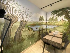 a dining room with a mural of trees and a table at Modern holiday home in Bazel with garden in Bazel