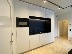 a kitchen with white cabinets and a large tv at Modern holiday home in Bazel with garden in Bazel
