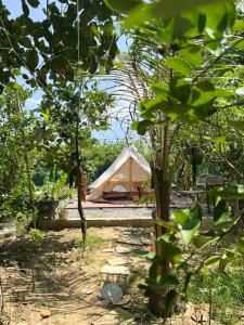 a tent in the middle of a field with trees at Littlefarm - Nam Cat Tien in Tân Phú