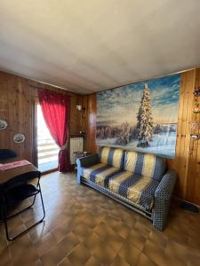 una sala de estar con sofá y una pintura en la pared en Passeggiando nel Verde en Collagna