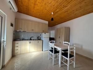 een keuken met een tafel en stoelen en een koelkast bij Vila Kylie in Ksamil