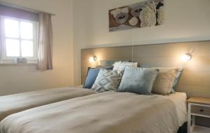 een slaapkamer met een groot bed met kussens en een raam bij Ons Binkje in Loon op Zand