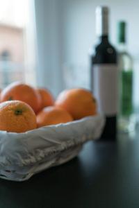eine Schüssel Orangen auf dem Tisch mit einer Flasche Wein in der Unterkunft Orange crush Barcelona in Barcelona