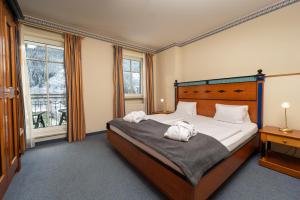 a bedroom with a bed with two towels on it at MONDI Hotel Bellevue Gastein in Bad Gastein